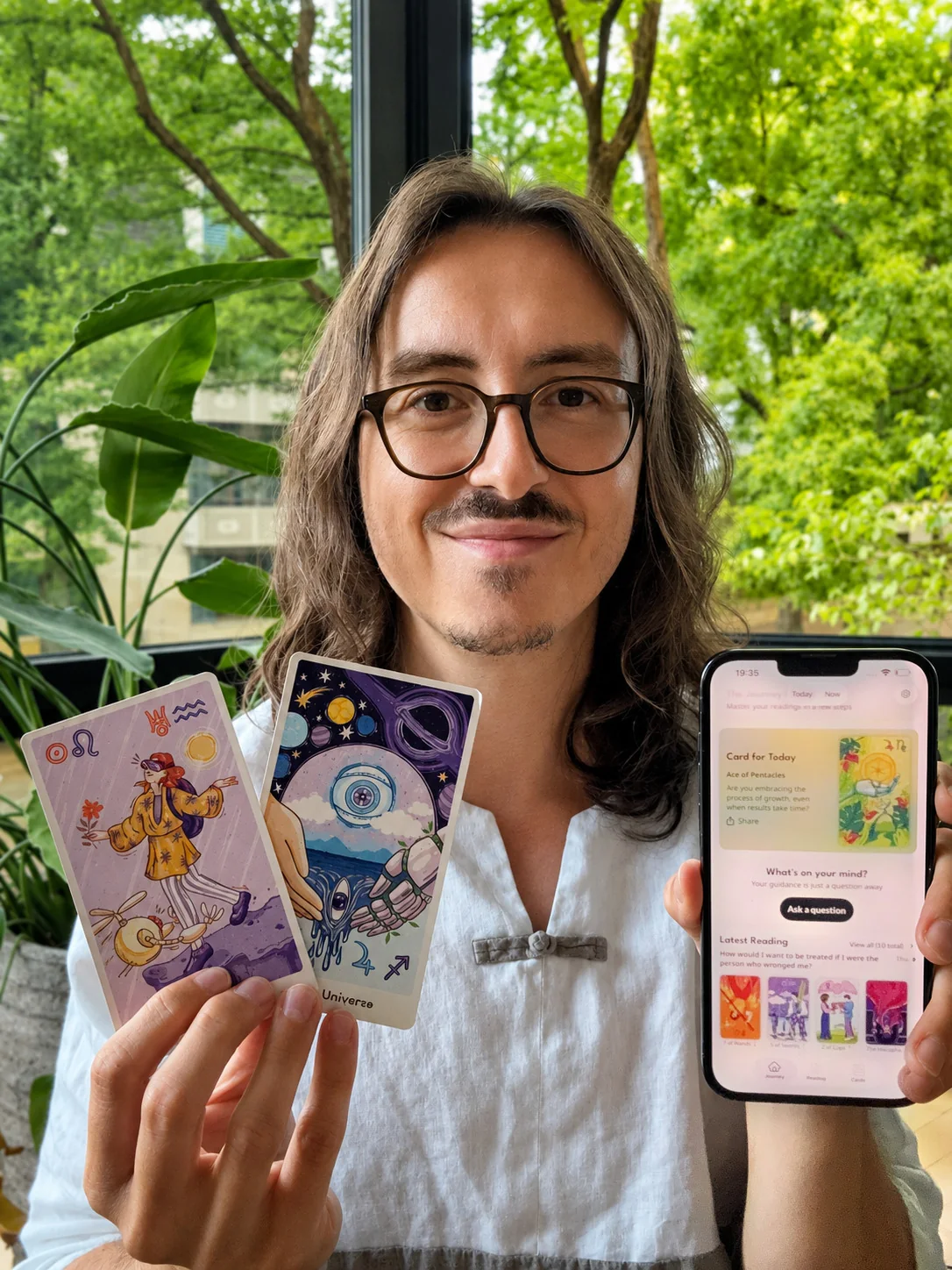 Dan holding Qybala cards and showing the Qybala app